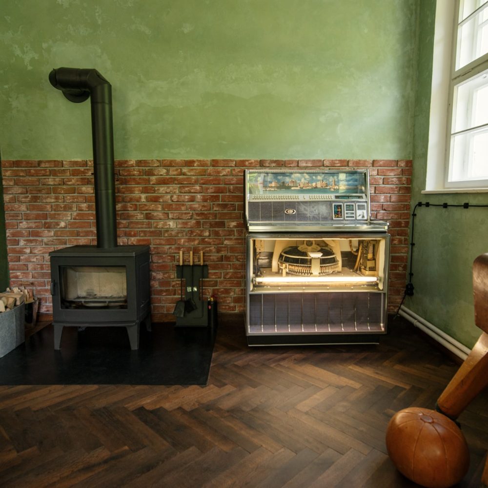 Kaminofen und Vintage-Jukebox in der Lounge im Ferienhaus Wolfsberghaus
