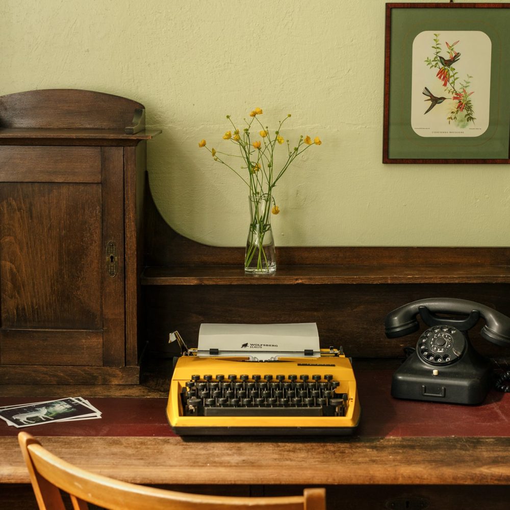 Sekretär mit gelber Schreibmaschine im Ferienhaus Wolfsberghaus